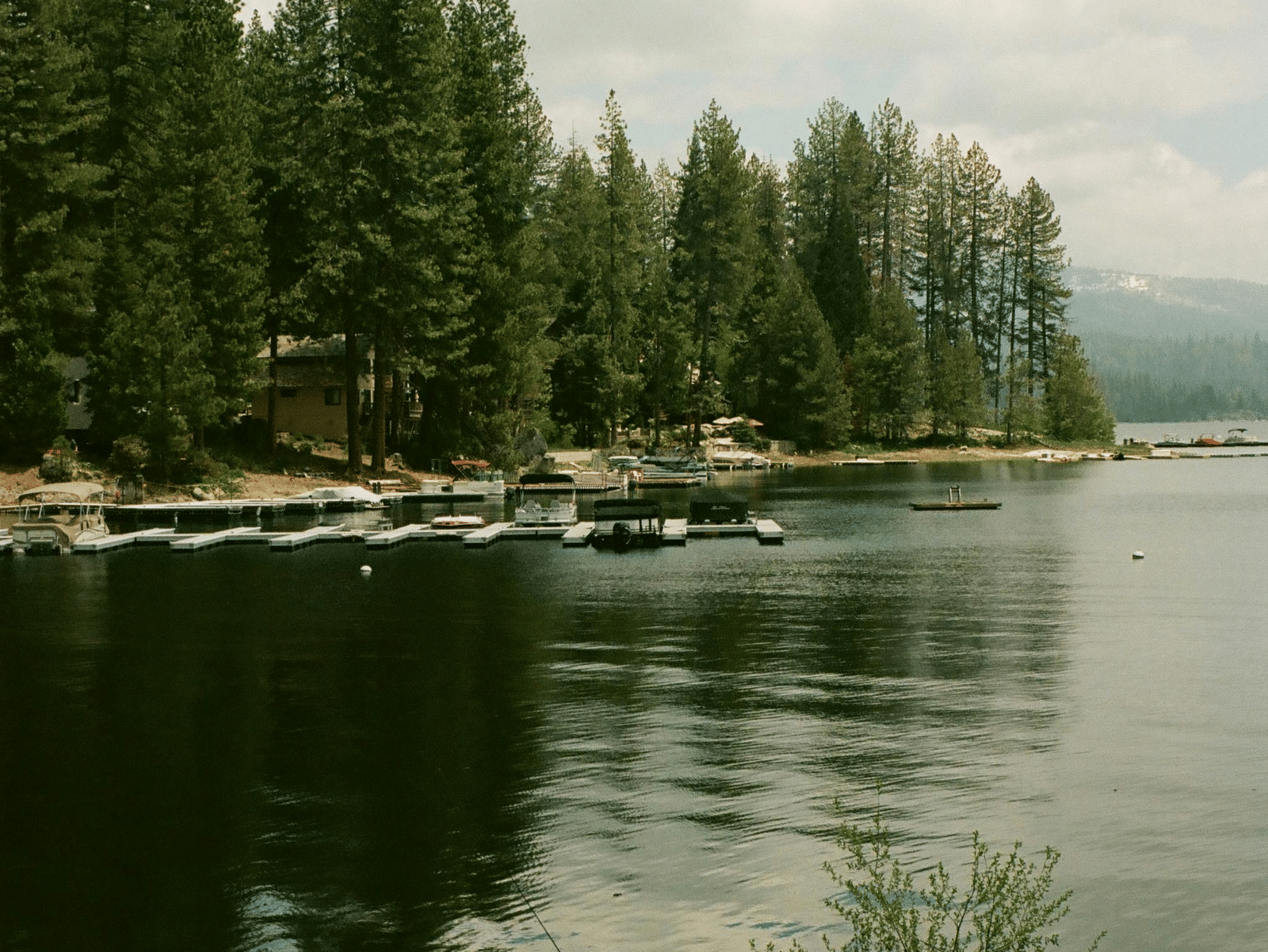 A peaceful lake with clear reflections of the sky and trees on the water's surface.