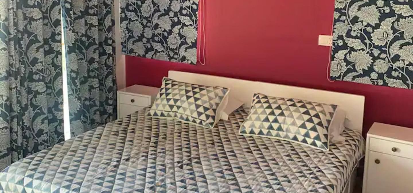 A large bed in a bedroom next to a nightstand at 3 BHK at SOUTHGATE KASAULI BY ZENQ.