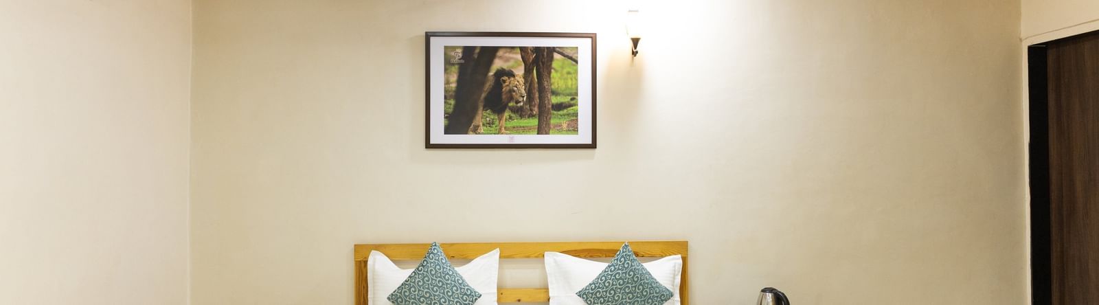 A neat room with a double bed, artwork, and warm lighting at Daksh Resort & Amusement Park.