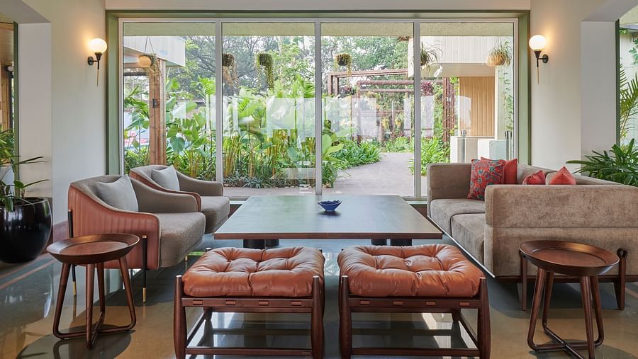 Bar seating area with stylish furniture, overlooking a lush garden view through large glass windows at The Dukes Retreat