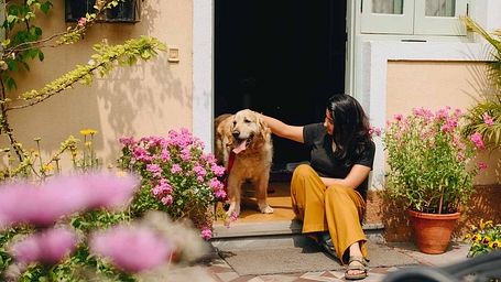 A woman petting a dog in front of the door of Karma Chalets.