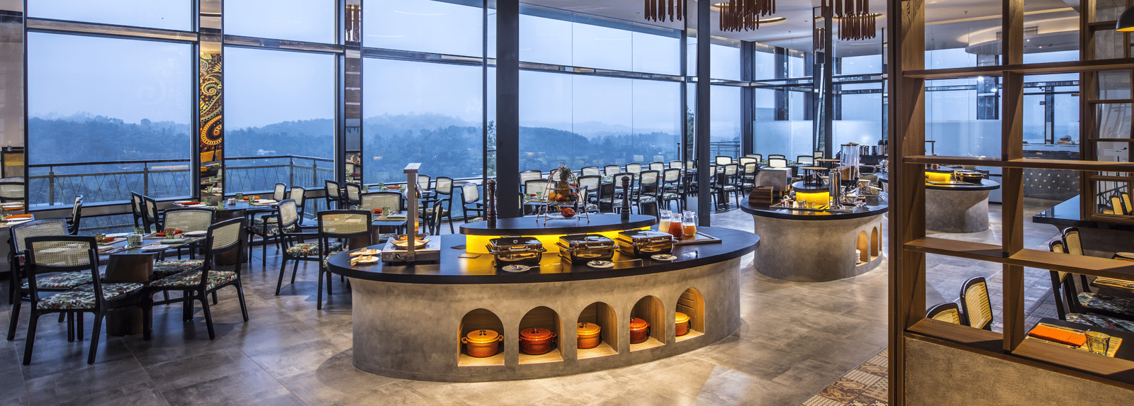  A modern restaurant with large windows offering panoramic views, elegant lighting, and a stylish interior design.