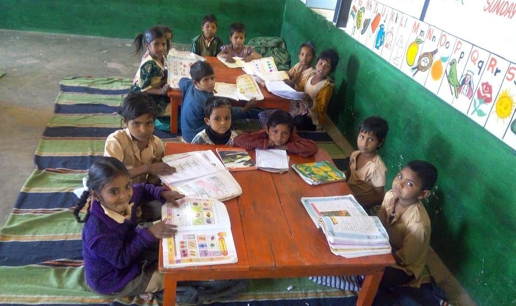 image of school kids reading books at a table in a government