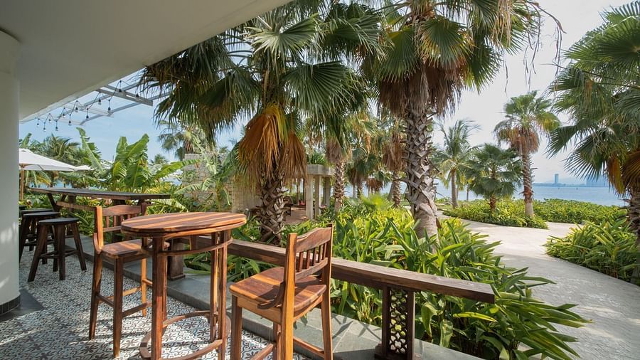 An image of a few chairs and tables placed on the deck - Alibu Resort Nha Thrang