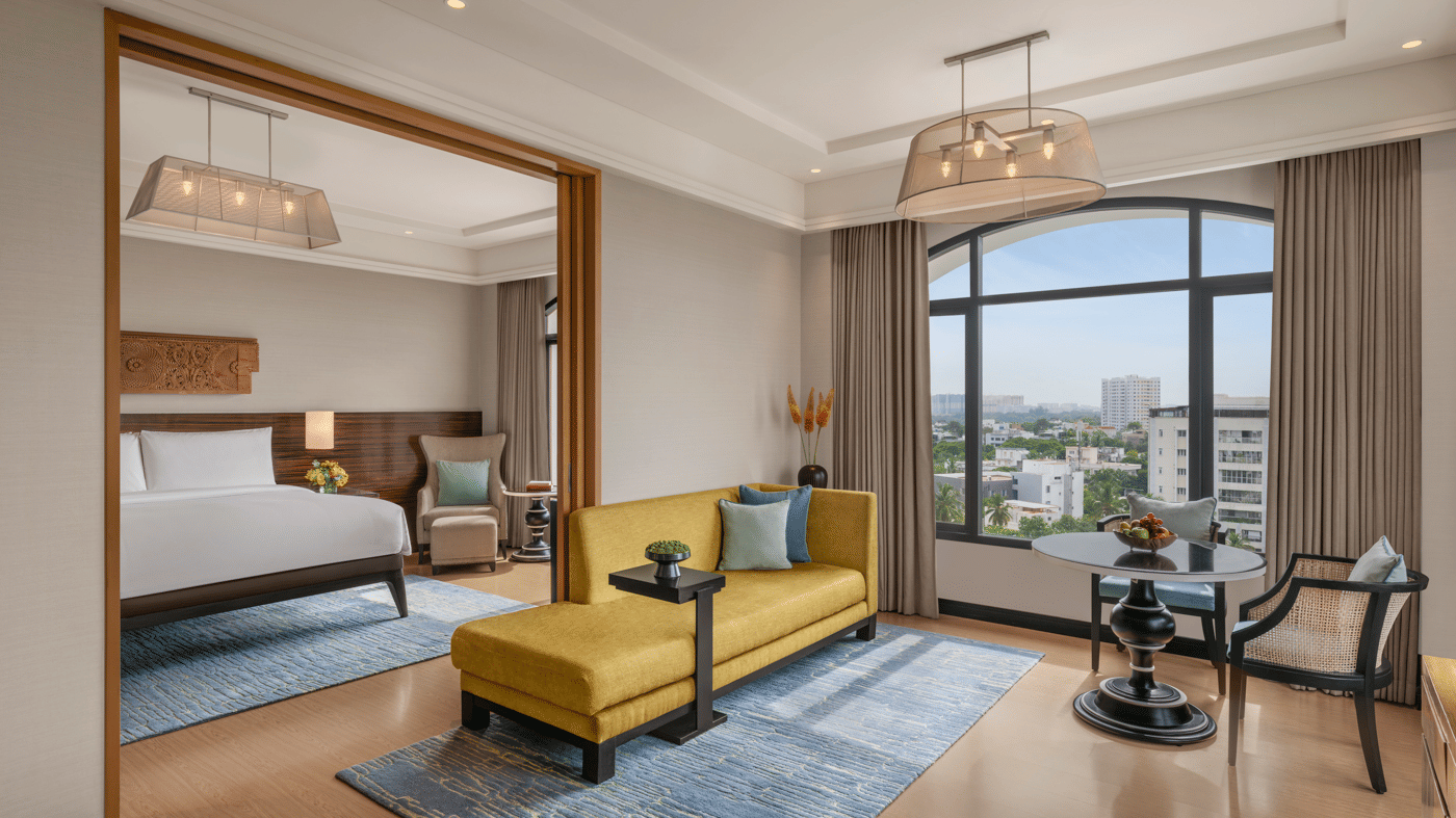 Bedroom with bed, desk, and side chair near windows at The Raintree, St. Mary’s Road.