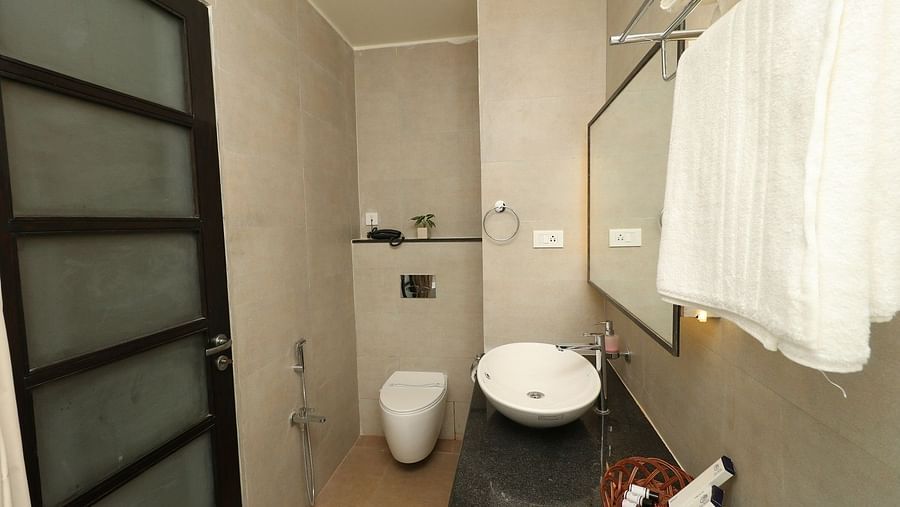 A hotel bedroom with a large bed, bedside lamps, and a ceiling fan, showcasing warm lighting and contemporary wooden and textured wall decor - Sea Hills Hotels, Sri Vijaya Puram (Port Blair)
