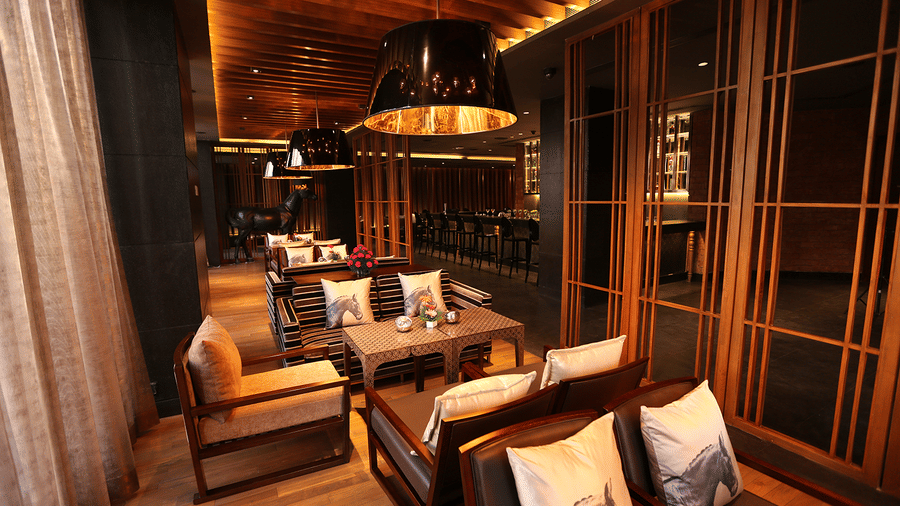  A dining space with chairs, tables, and cushions set in a warm lighting.