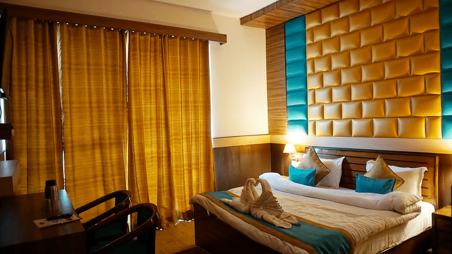 Double Bed Premium room with blue and white bed covers at Hotel Panchvati Inn, Joshimath 2