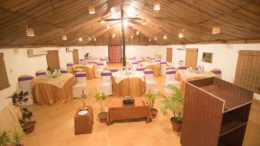  A wide top view shot of c banquet hall with podium, arranged tables and chairs in  Lotus Eco Beach resort konark.
