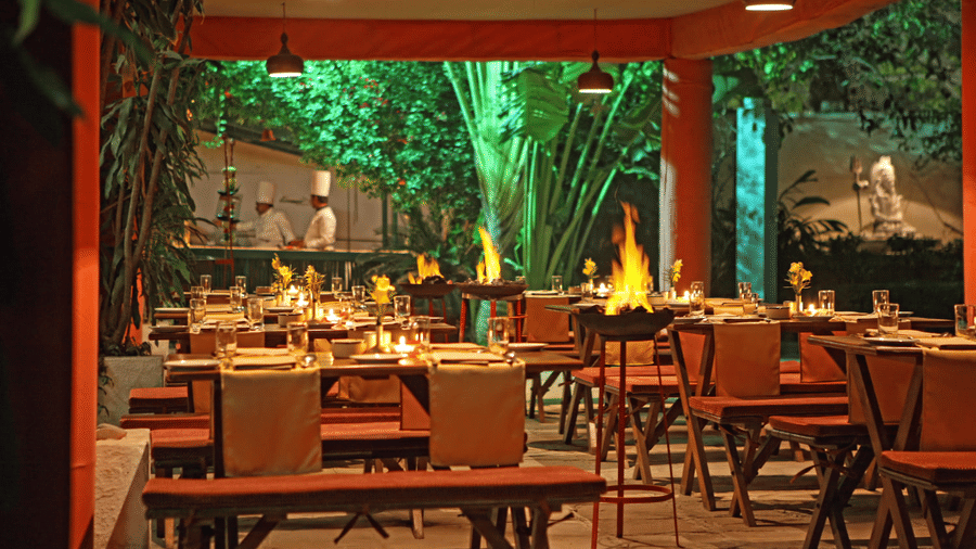 A dining area with chairs, tables, and plants in the backdrop at Clarks Hotels.
