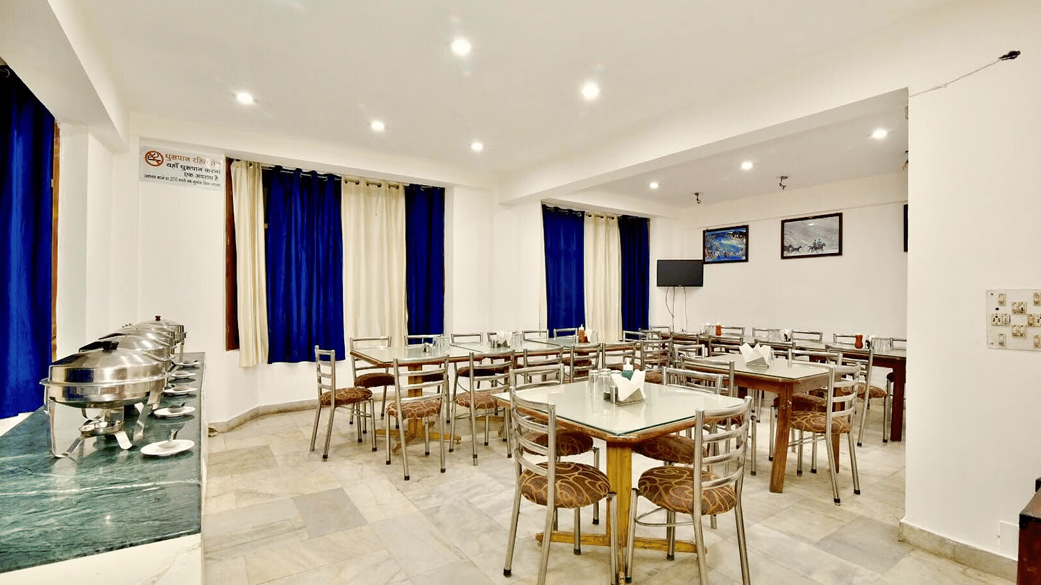 Well-lit interiors of the restaurant at DLS Hotel Devlok, Manali with the buffet arrangement towards the side