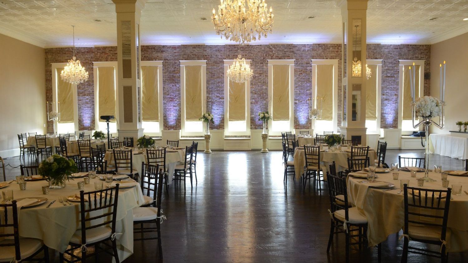 Grand banquet hall with crystal chandeliers and white linens perfect for events and celebrations