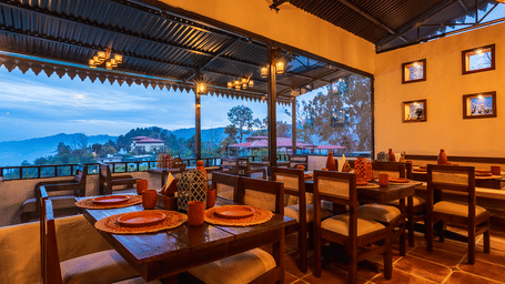 Indoor-outdoor restaurant transition area overlooking the valley at Maati Resort By The Lake Hill, Jeolikote.