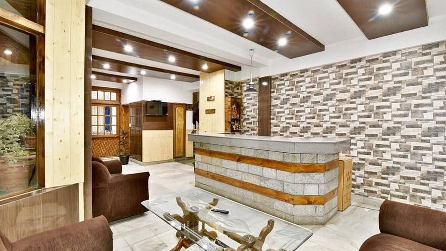 The reception desk in the well-lit lobby area of DLS Hotel Devlok, Manali