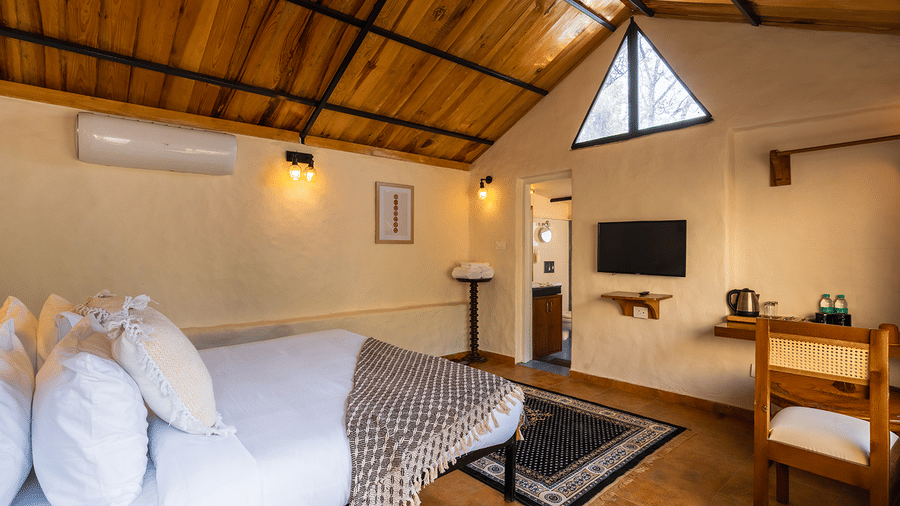 Rustic bedroom with a sloped wooden ceiling and rustic mountain lodge aesthetic at Maati Resort By The Lake Hill, Jeolikote.