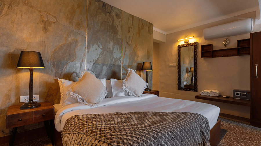 Premium bedroom setup with a king sized bed, decorative lamps, and air conditioning at Maati Resort By The Lake Hill, Jeolikote.