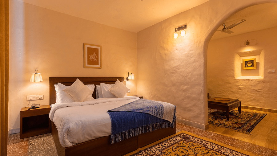 Warmly lit bedroom with a king sized bed and elegant decor at Maati Resort By The Lake Hill, Jeolikote.