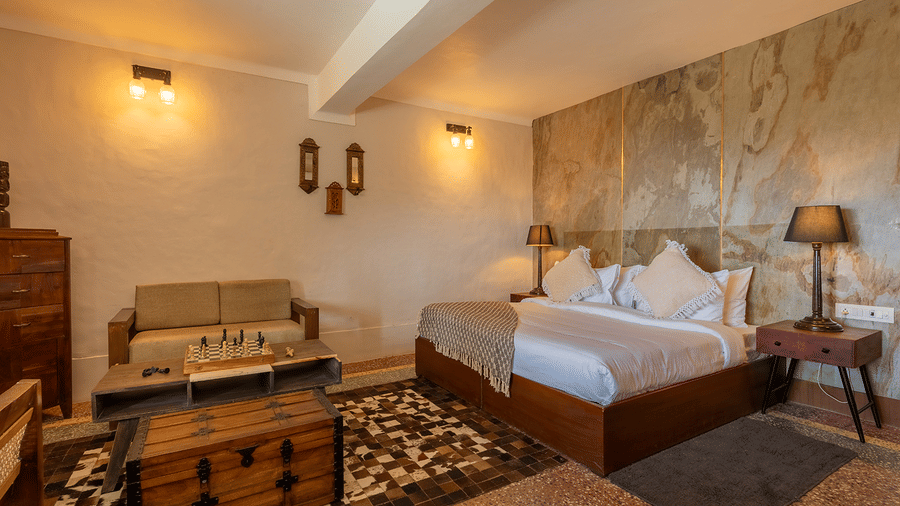 A master bedroom featuring a stunning natural stone accent wall and warm lighting at Maati Resort By The Lake Hill, Jeolikote.