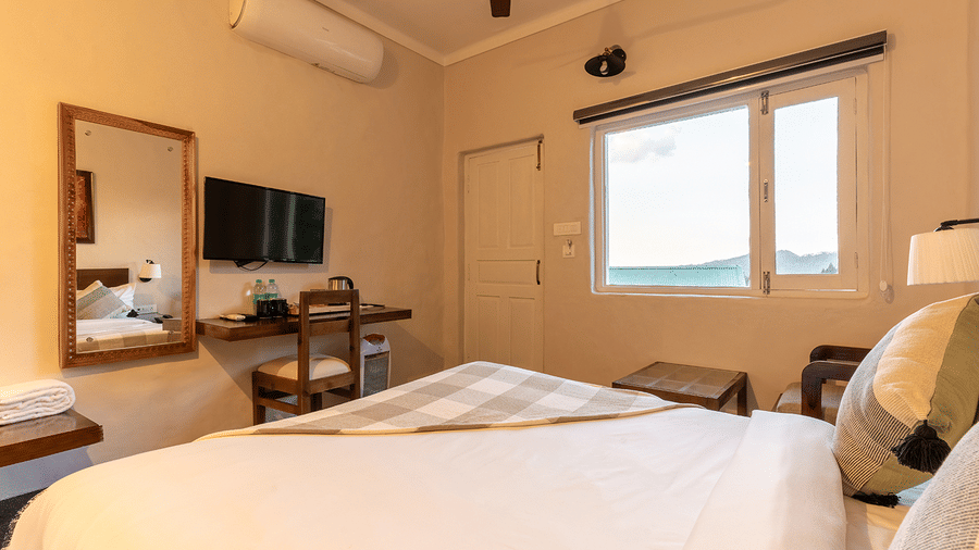 Well-appointed room featuring air-conditioning, a vanity mirror, and a mountain-view window at Maati Resort By The Lake Hill, Jeolikote.