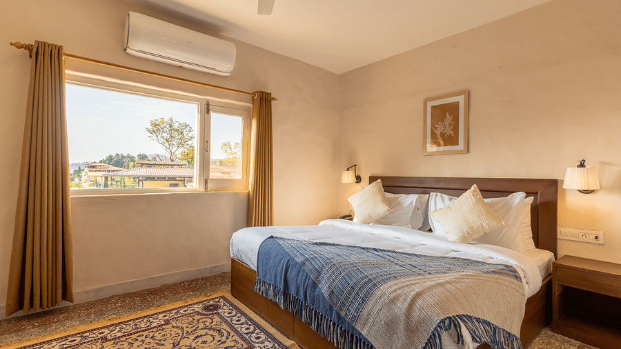 Spacious luxury bedroom with a large window offering natural light and scenic views at Maati Resort By The Lake Hill, Jeolikote.