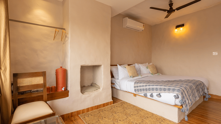 Clean, minimalist bedroom with warm wooden flooring and soft ambient lighting at Maati Resort By The Lake Hill, Jeolikote.