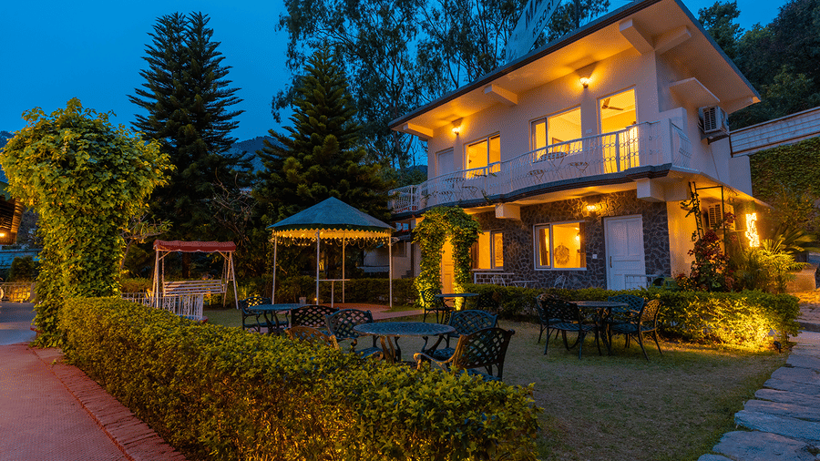 The glowing exterior of the resort buildings and garden area illuminated at night at Maati Resort By The Lake Hill, Jeolikote.