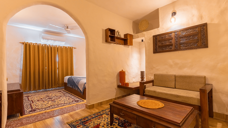 Interior view of a suite showing the living space with traditional rugs and arched doorways at Maati Resort By The Lake Hill, Jeolikote.