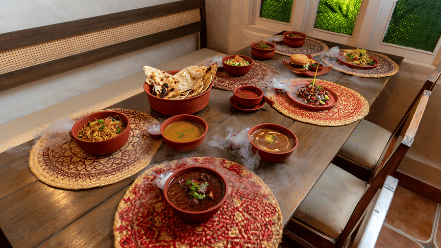 A traditional Indian feast served in clay pots on a rustic wooden table at Maati Resort By The Lake Hill, Jeolikote.