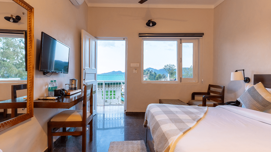 Bright and welcoming guest suite with a workstation, television, and mountain-facing window at Maati Resort By The Lake Hill, Jeolikote.
