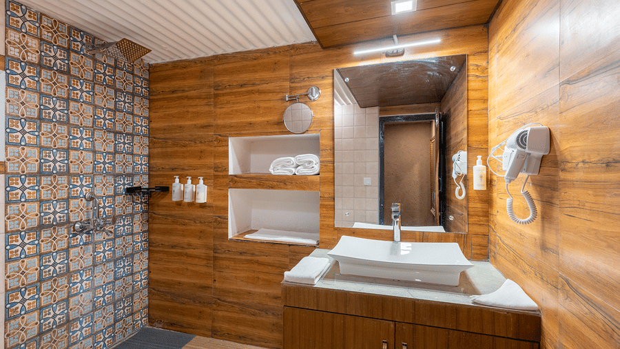 Luxury bathroom featuring warm wood panelling and a modern designer washbasin at Maati Resort By The Lake Hill, Jeolikote.