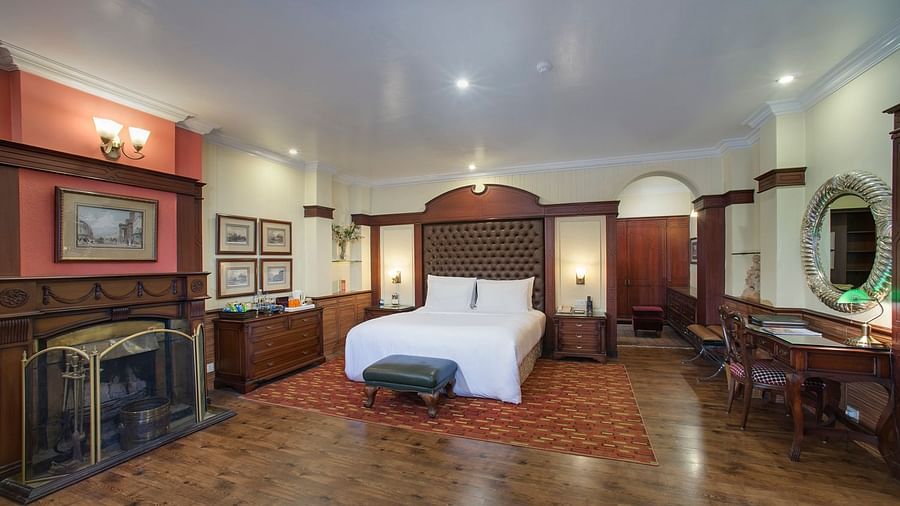 view of a king size bed in the middle and a fireplace to its left and a dressing table to its right - Mayfair Hill Resort, Darjeeling