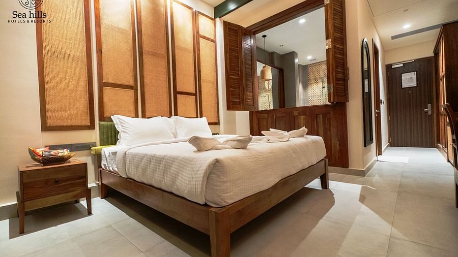 Cosy bedroom with a comfortable bed, elegant decor, and large windows that open to a garden view - Sea Hills Resort, Swaraj Dweep (Havelock)