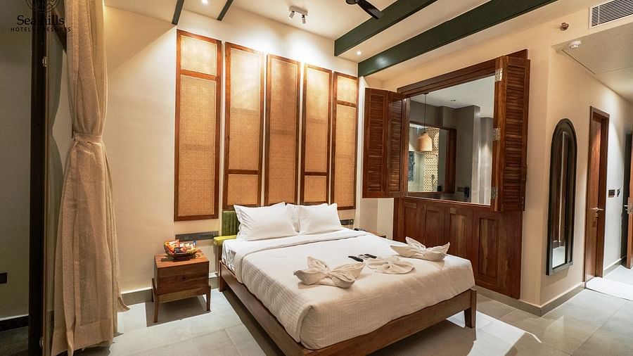 Stylish wooden bed frame in a well-lit bedroom with elegant furnishings, creating a comfortable and welcoming space - Sea Hills Resort, Swaraj Dweep (Havelock)