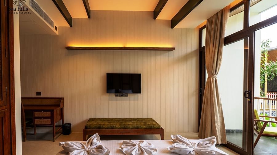 Spacious bedroom with large windows, wooden furniture, and fresh linens, providing a serene environment - Sea Hills Resort, Swaraj Dweep (Havelock)