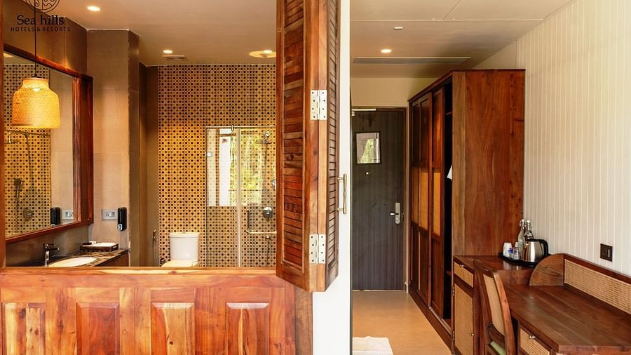 Stylish room with warm wooden interiors, a comfortable bed, and thoughtful touches such as a plush chair and accessories - Sea Hills Resort, Swaraj Dweep (Havelock)