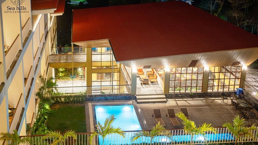 An aerial night view of a brightly lit hotel complex with a swimming pool and lush greenery. - Sea Hills Resort, Swaraj Dweep (Havelock)