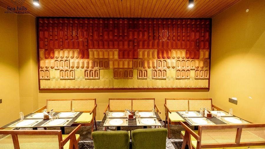 A modern dining room with organised seating and decorative wall art. - Sea Hills Hotels & Resorts, Havelock Island
