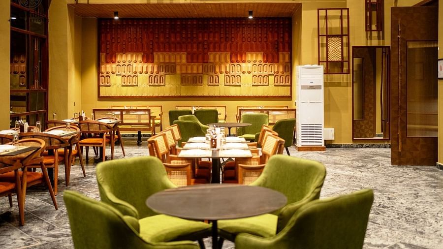 A comfortable restaurant setting with green upholstered chairs and round tables. - Sea Hills Resort, Swaraj Dweep (Havelock)