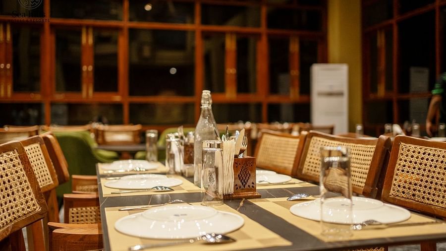 Several dining tables set in a restaurant with wooden chairs - Sea Hills Resort, Swaraj Dweep (Havelock)
