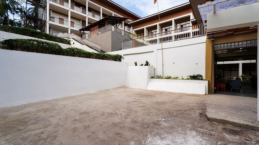 A spacious outdoor courtyard or parking area next to a hotel building, with white walls and a clear sky. - Sea Hills Resort, Swaraj Dweep (Havelock)