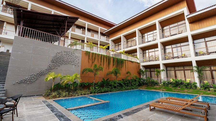 An exterior shot of a contemporary hotel building featuring a rectangular swimming pool and outdoor seating. - Sea Hills Resort, Swaraj Dweep (Havelock)