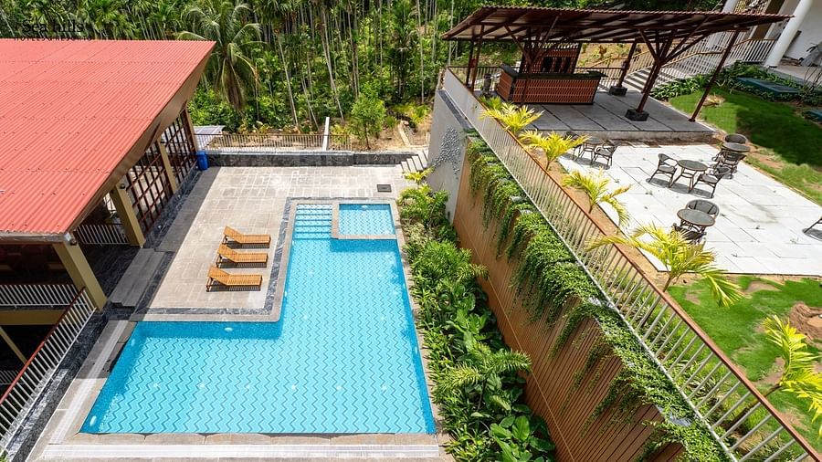 An aerial view looking down at two rectangular swimming pools surrounded by greenery and buildings. - Sea Hills Resort, Swaraj Dweep (Havelock)