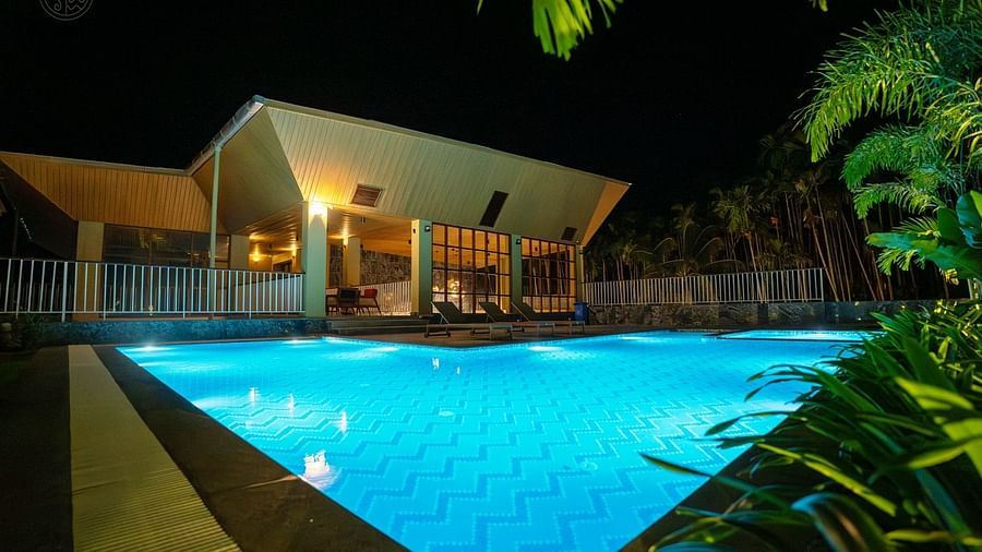 A swimming pool area at night, illuminated with blue lights, showcasing modern architecture. - Sea Hills Resort, Swaraj Dweep (Havelock)