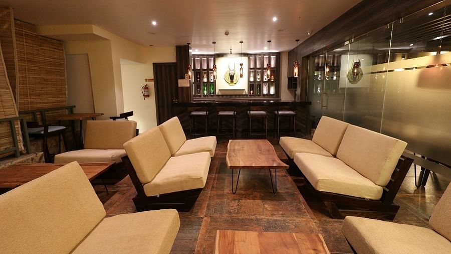 A spacious and inviting lounge or common area with several light-coloured sofas and low wooden tables, set in a well-lit, open-plan space - Sea Hills Hotels, Sri Vijaya Puram (Port Blair)