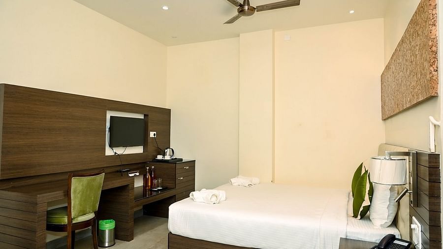 A clean and contemporary hotel bathroom with a toilet, a basin, and a shower area, featuring light-coloured walls and dark accents - Sea Hills Hotels, Sri Vijaya Puram (Port Blair)