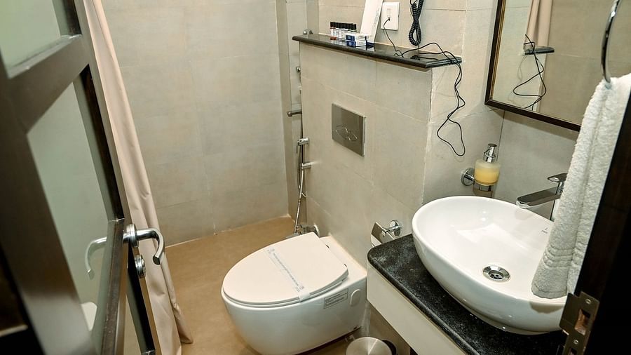 A hotel bedroom with a large white bed, a television mounted on the wall, and a desk with a chair, indicating a functional and comfortable space - Sea Hills Hotels, Sri Vijaya Puram (Port Blair)