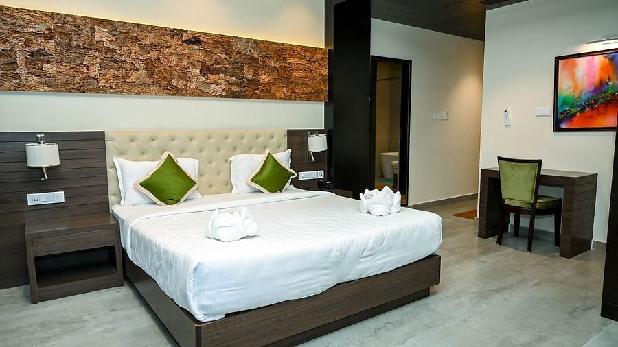 Another perspective of the hotel room, showcasing the large bed, modern furnishings, and the natural light streaming in from the balcony - Sea Hills Hotels, Sri Vijaya Puram (Port Blair)