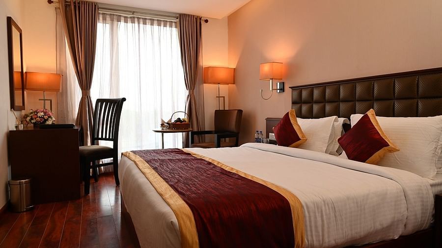 Raaj Bhaavan Clarks Inn - interior view of the bedroom featuring a queen size bed and a coffee table