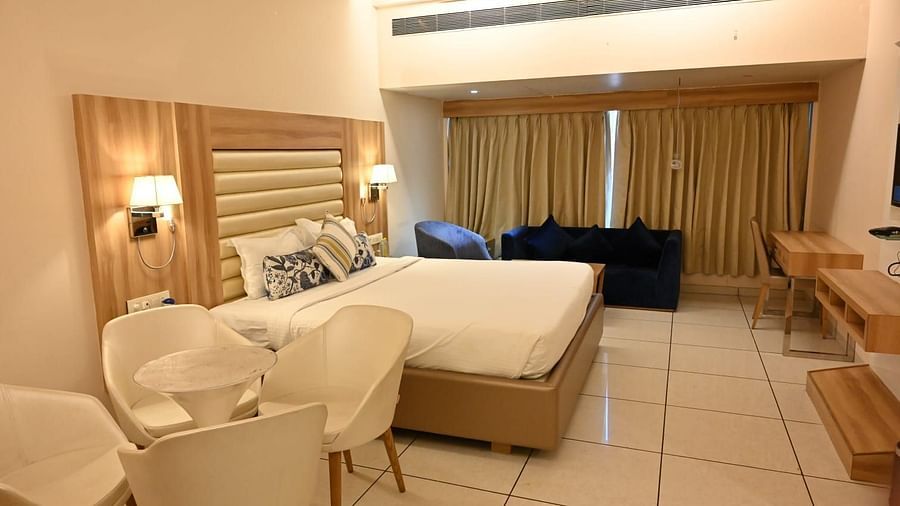 Unique hotel room design at Rang Lords Inn, with a bed, seating, and distinct wooden paneling for a modern touch