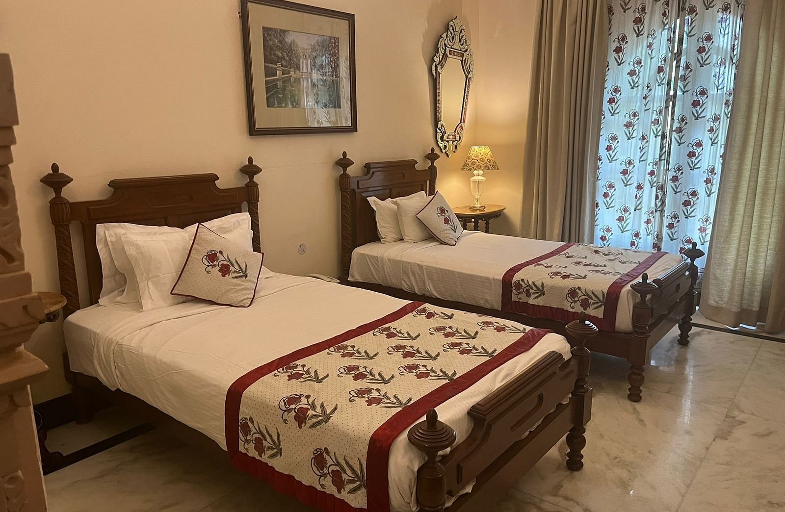 A cosy twin bedroom with carved wooden decor, warm lighting, and traditional accents - Khas Bagh, Jaipur.